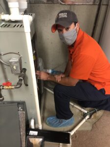 ryan doing a furnace repair - COVID safety with PPE