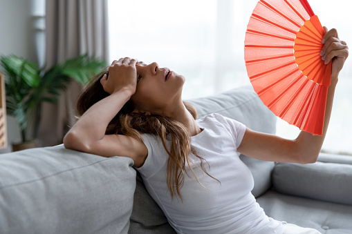 exhausted girl with paper fan